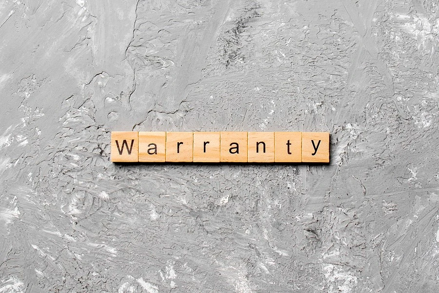 “Warranty” Spelled In Scrabble Tiles “Warranty” spelled in letter tiles on a gray background
